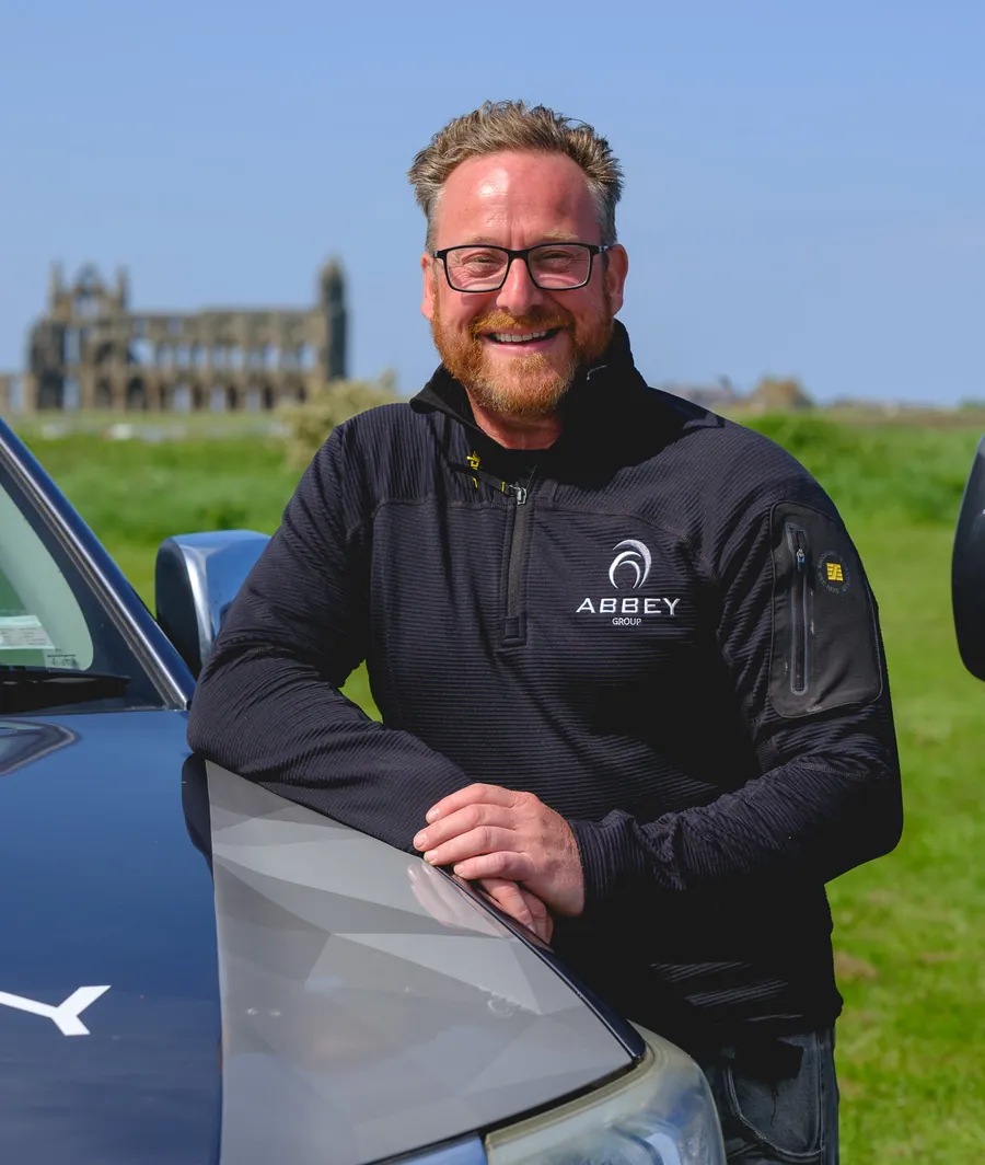 James Eddon, Managing Director of Abbey Group, beside a van with Whitby Abbey behind
