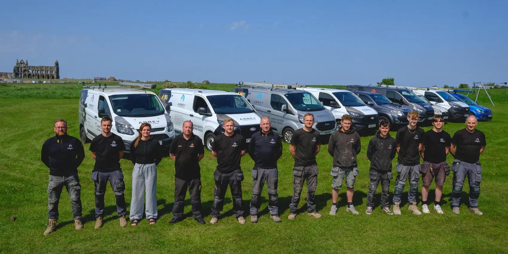 The Abbey Group team with their vans in front of Whitby Abbey