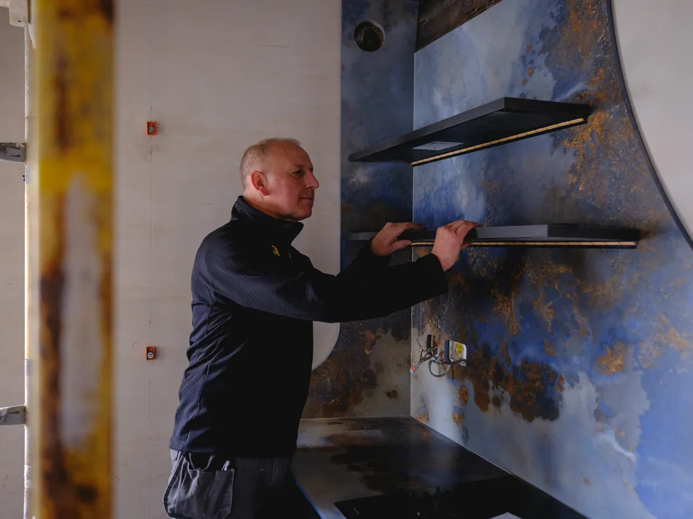 Abbey Group joiner fitting floating shelves to a feature wall