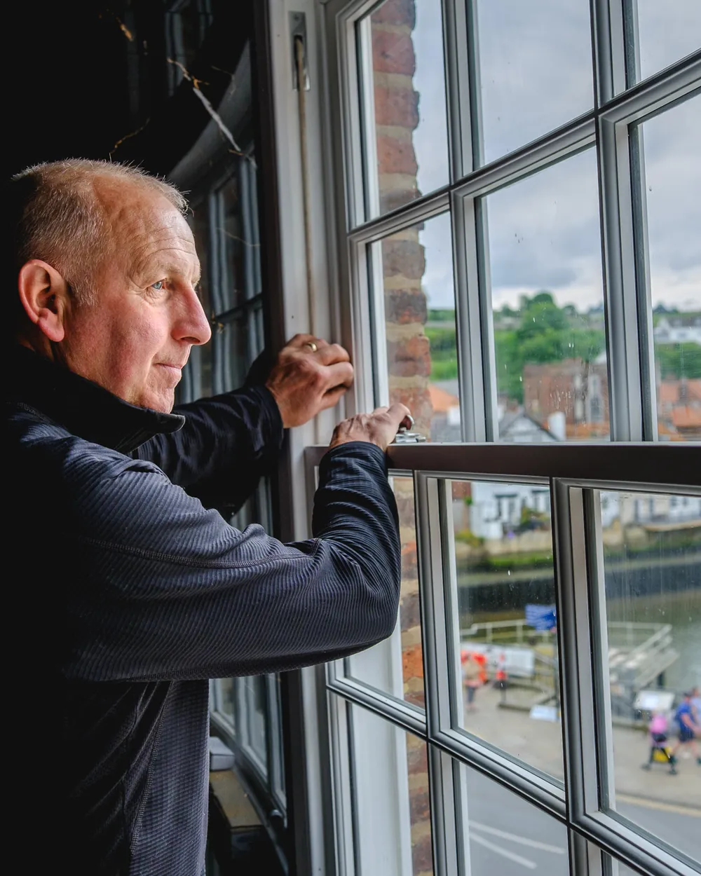 Abbey Group joiner fitting a window above Whitby harbour