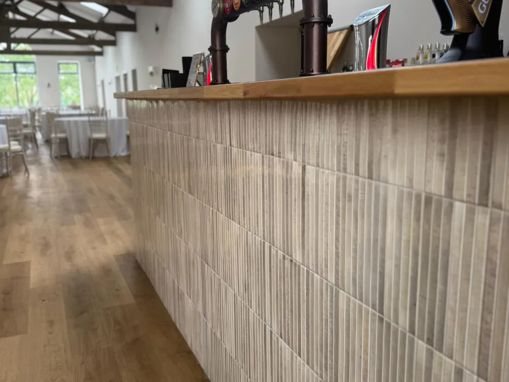 Close-up of the oak worktop and timber bar front fitted by Abbey Group