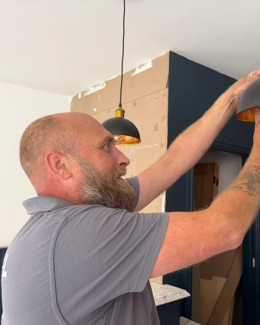 Abbey Group electrician fitting a light fixture in a Whitby property