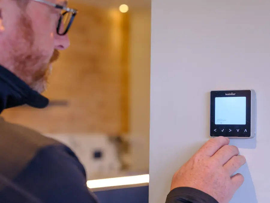Abbey Group engineer setting a smart heating control in a Whitby home