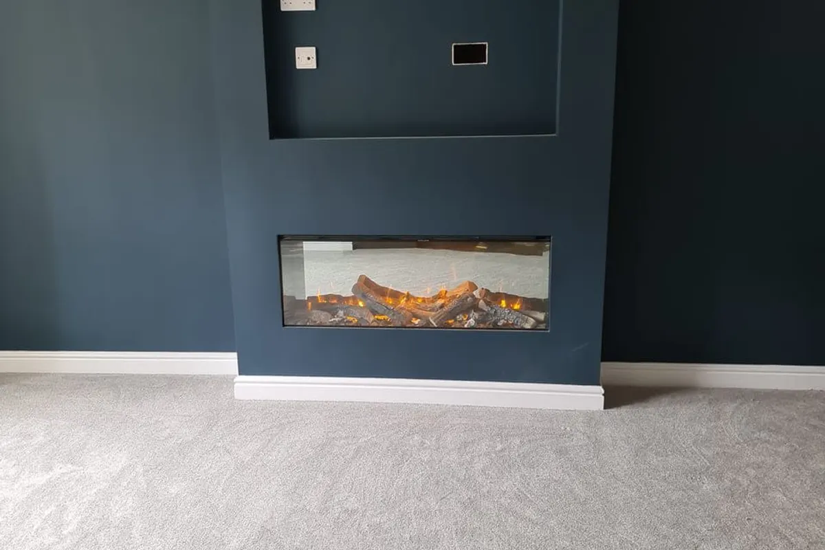 Living room feature wall with an inset electric fire, renovated by Abbey Group