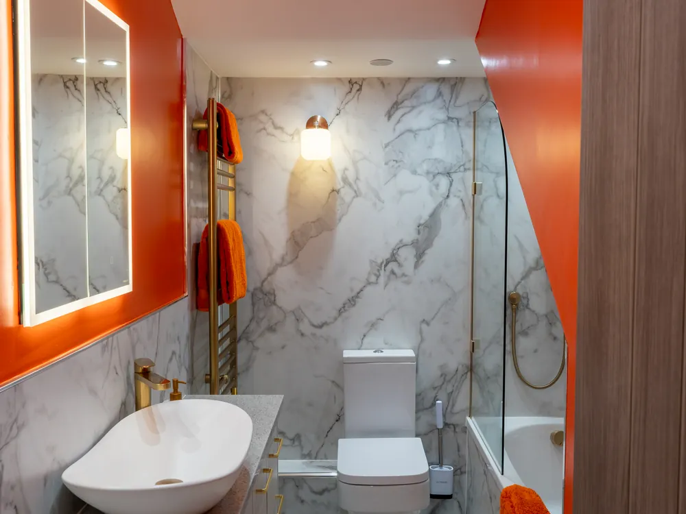 Marble en-suite bathroom with brushed gold fittings in the Riviera renovation in Whitby by Abbey Group