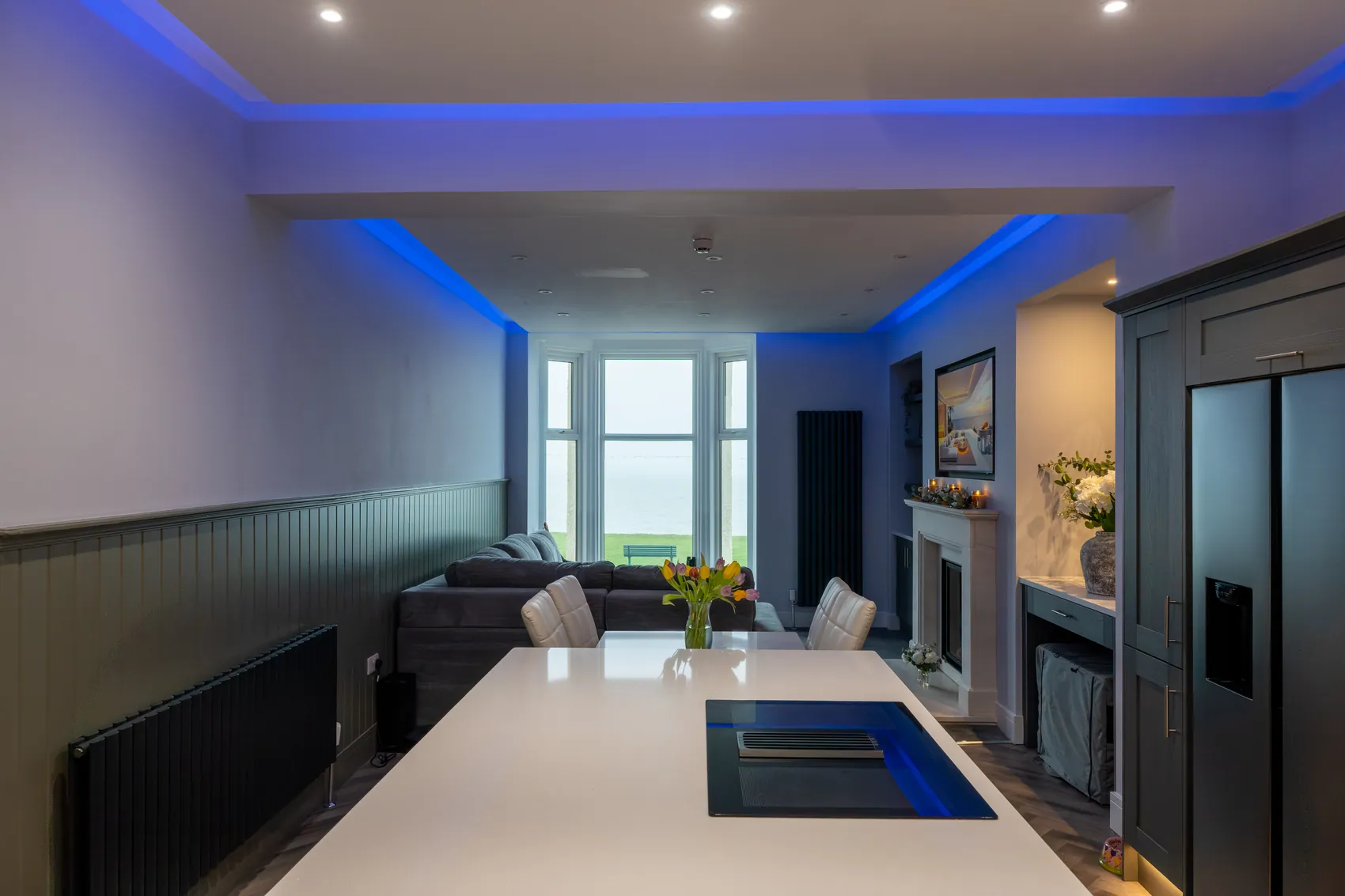 Open-plan kitchen and living space with a sea view in the Riviera renovation in Whitby by Abbey Group